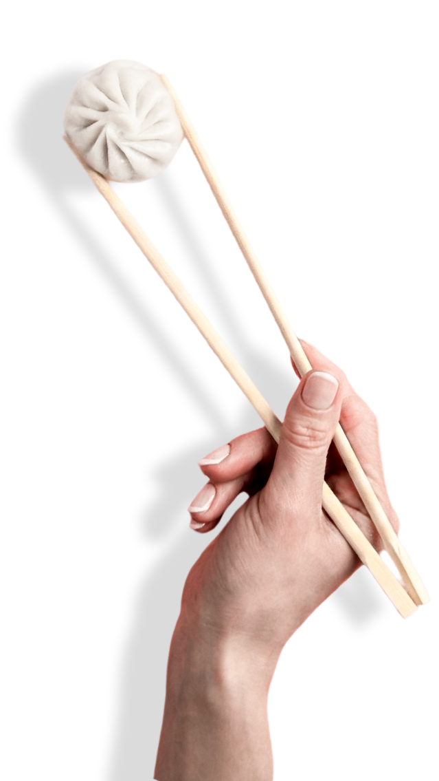 A momo lifted on chopsticks at MOMO 365 & BAR